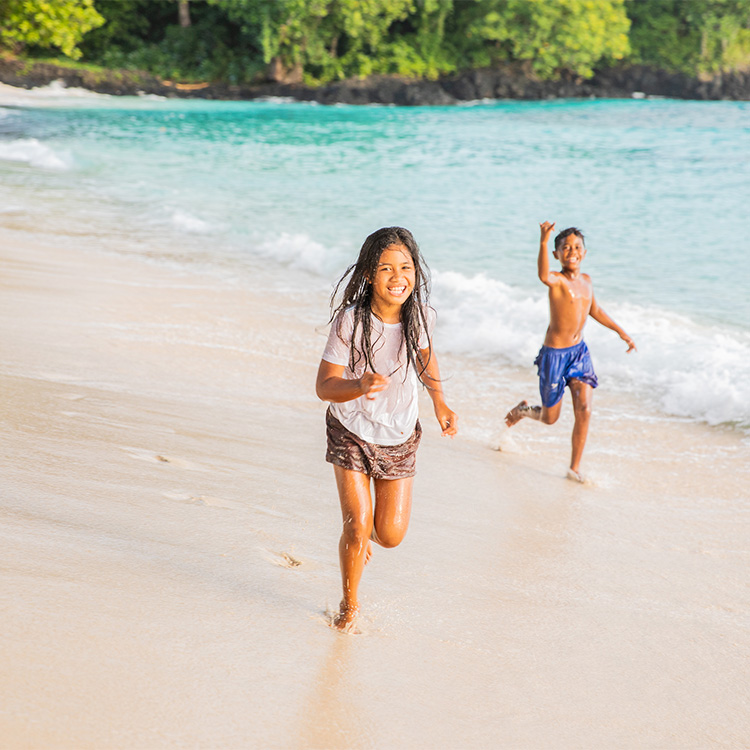 Samoa children run on sandy beach